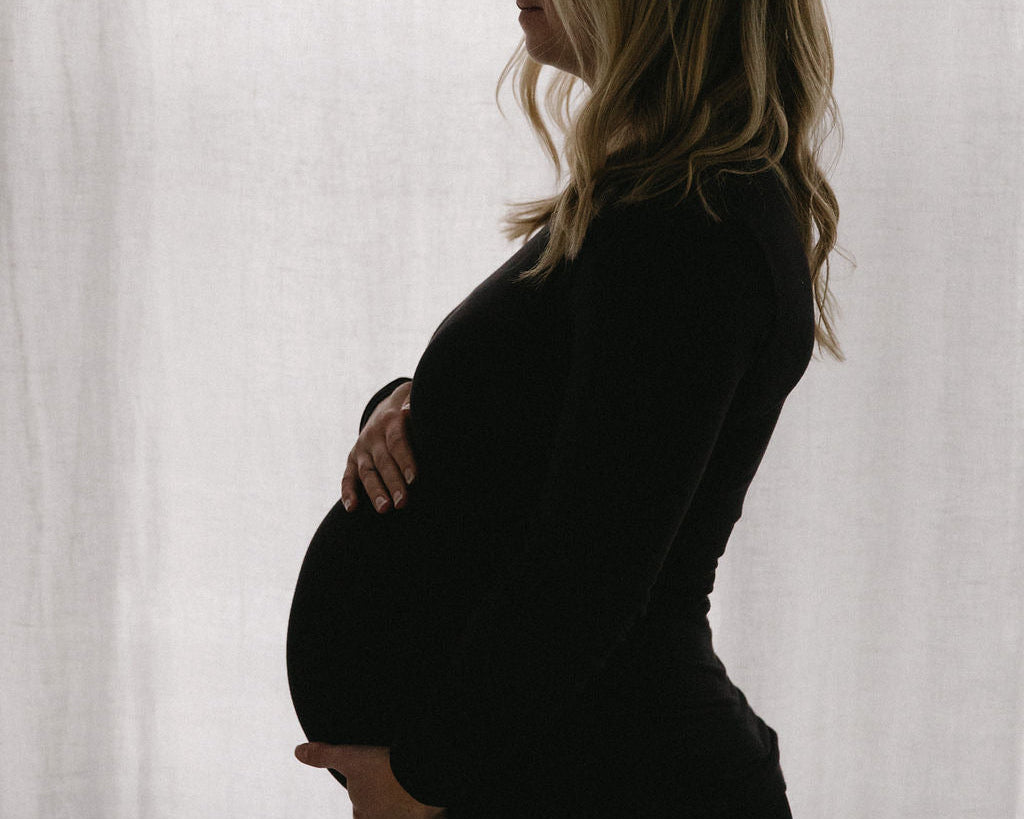 Pregnant woman holding belly webster