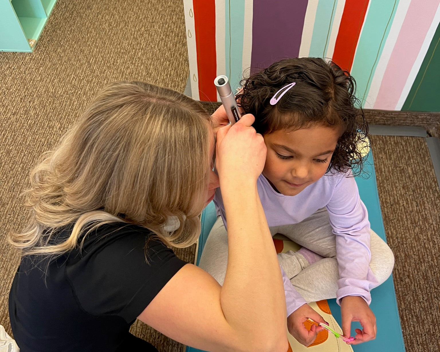 Pediatric provider performing ear and sinus drainage technique on infant