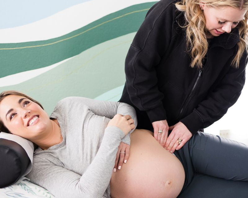 pregnant woman having labor prep in chiropractor office