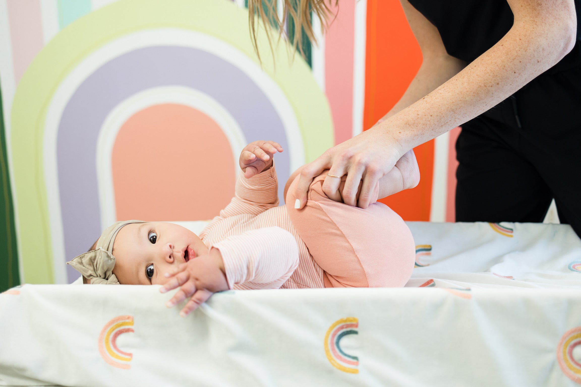 Baby chiropractor stretching baby’s lower body