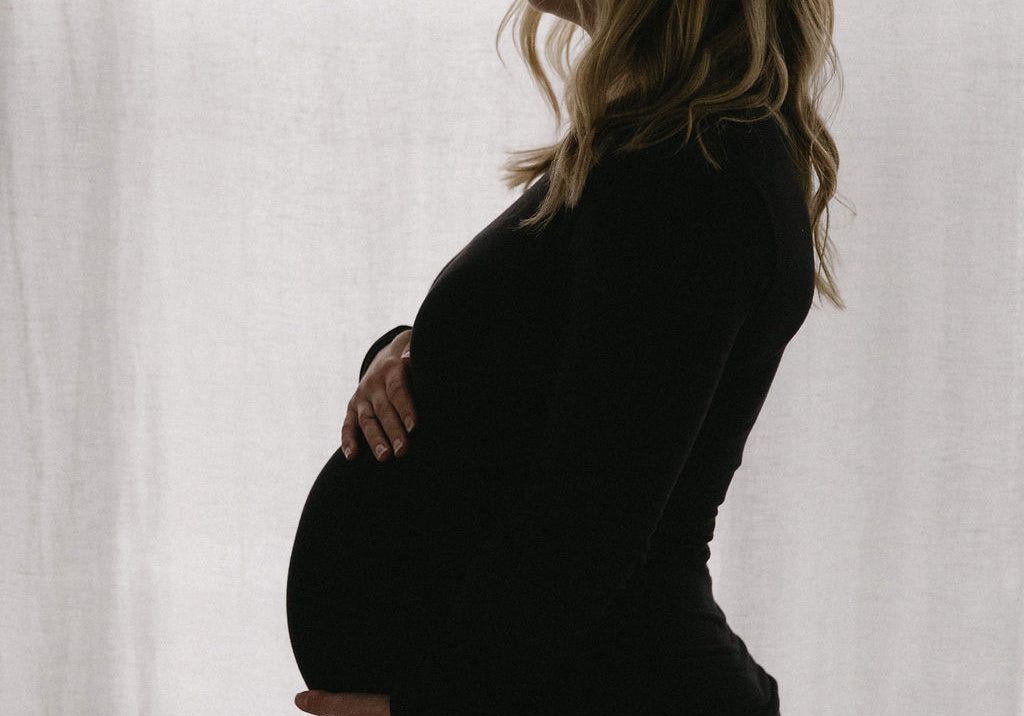 Pregnant woman holding belly webster 