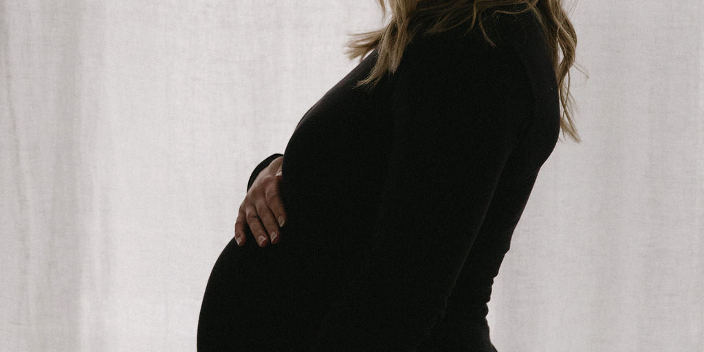 Pregnant woman holding belly webster 