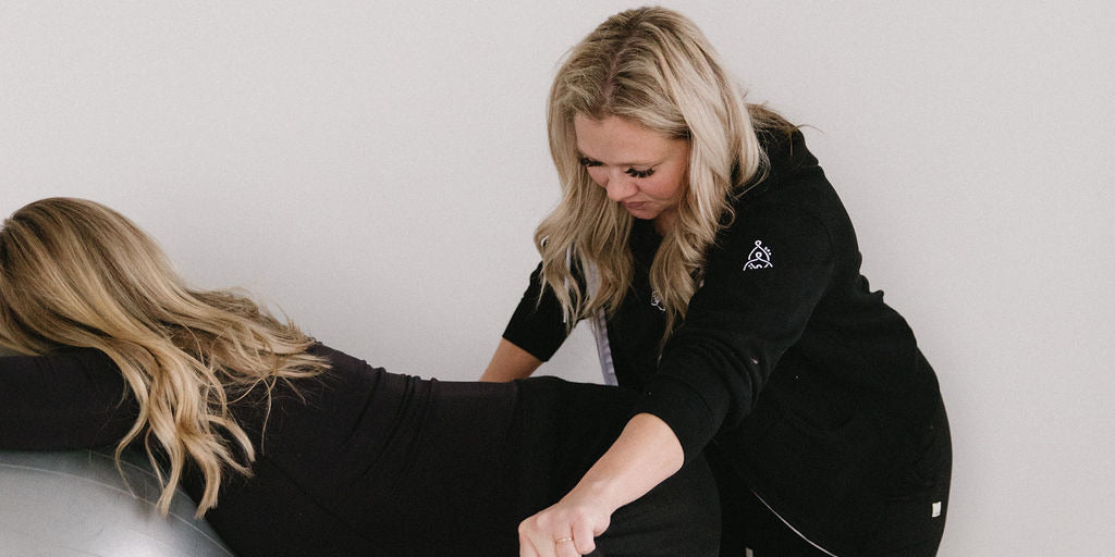 Woman chiropractor does breech baby exercise on a pregnant patient