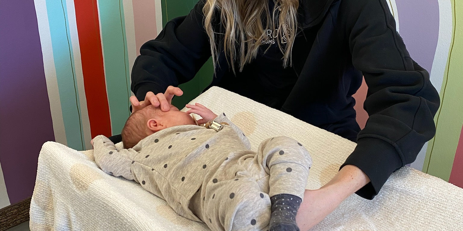 Baby chiropractor performing infant craniosacral therapy